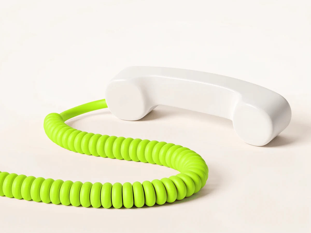 Un auricular de teléfono blanco con el cable en espiral en lima